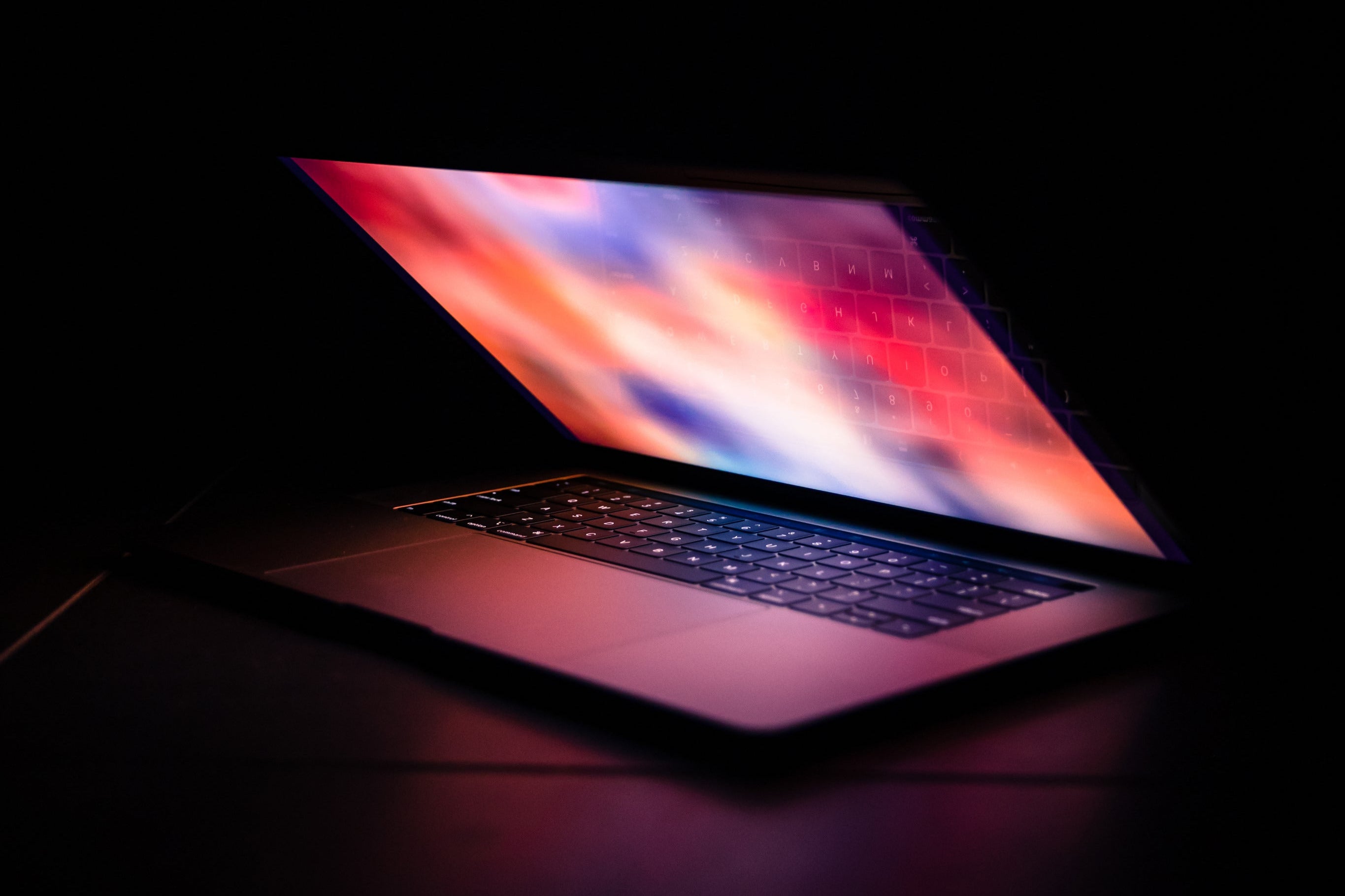 Minimalist photo of a partially open, glowing laptop in a dark room — symbolizing digital responsibility, secure data handling, and quiet tech.
